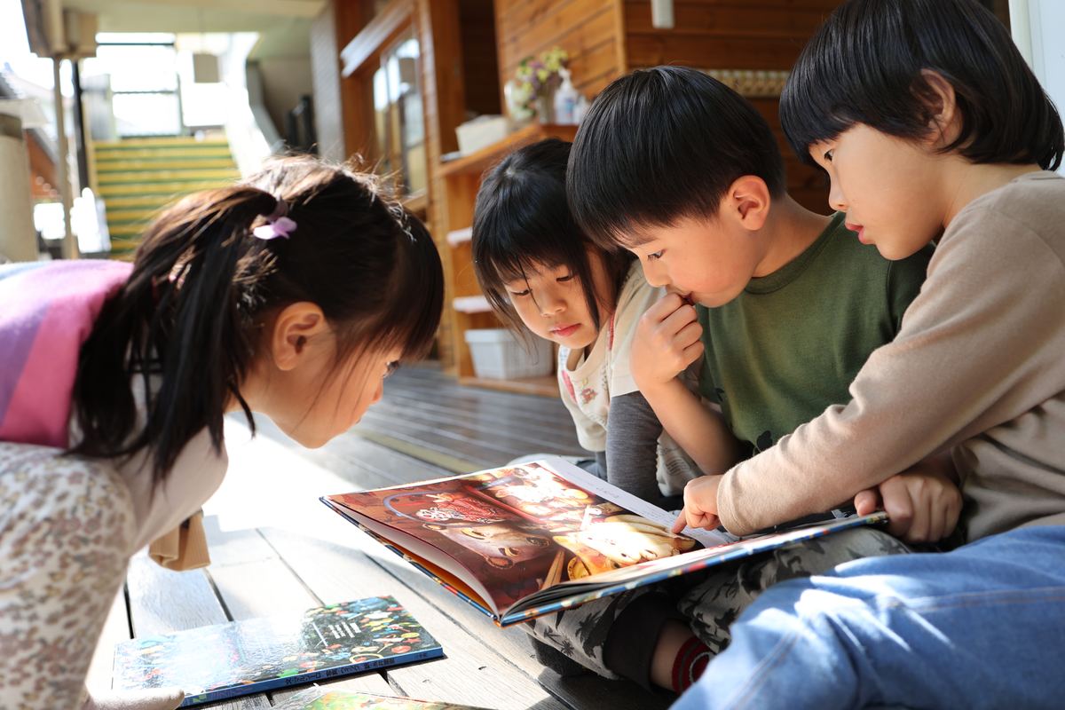 一緒に絵本を読むこどもたち